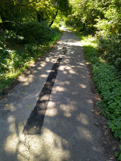 Long crack in path filled with new tarmac strip